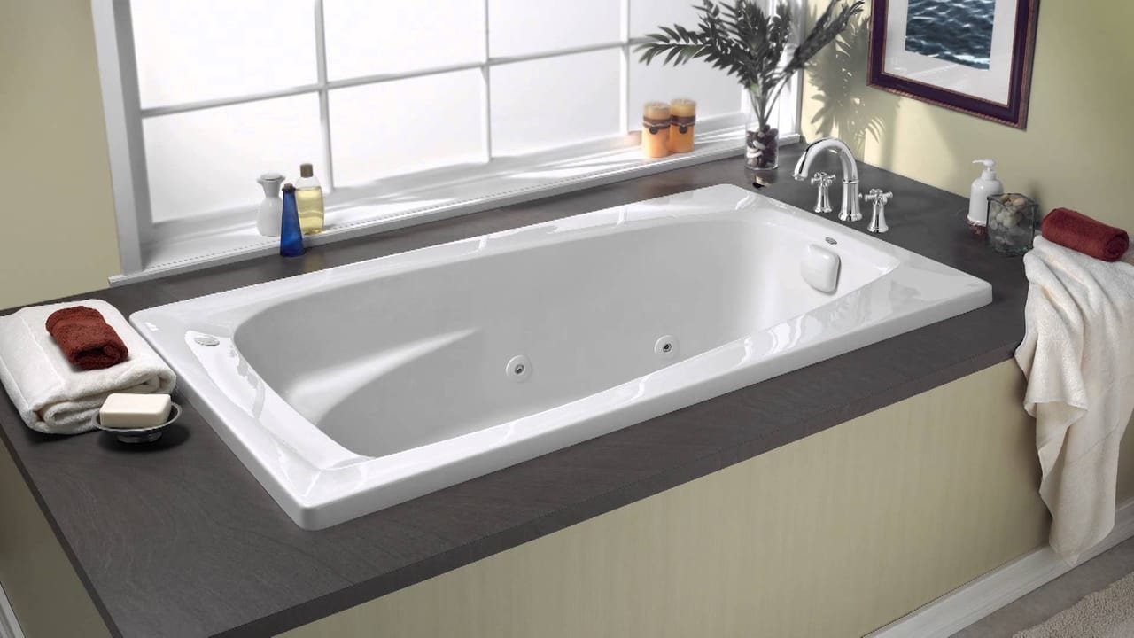 Bañera de hidromasaje encastrada junto a una ventana